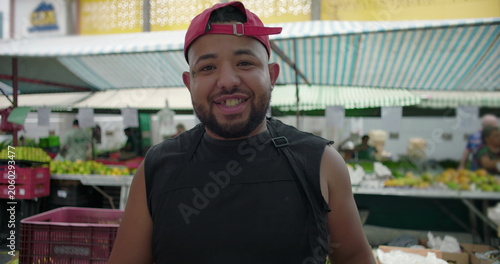 Obraz na plátně Market vendor smiling at camera at outdoor produce market, friendly service, loc