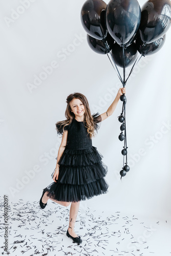 Foto A happy child with black balloons at a holiday photo shoot.