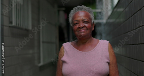 Foto African American elderly woman outdoors standing in narrow passage smiling gentl