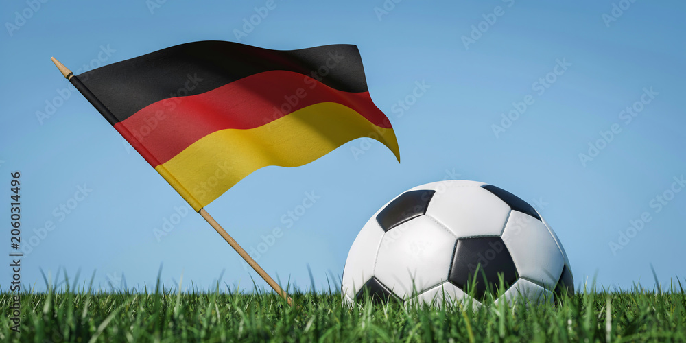 Naklejka premium Black Red and Yellow National Flag Waving Beside Soccer Ball on Green Grass Field