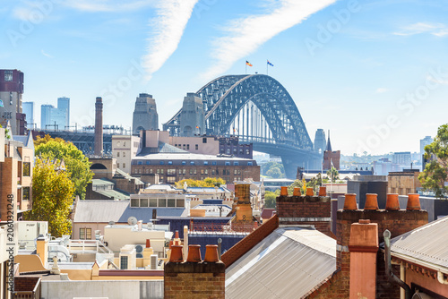 Sydney Harbour Bridge as seen the historic suburb of The Rocks on a sunny autumn day. Rooftops with old chimney pots are visible in foreground.. Sydney Austrialia.