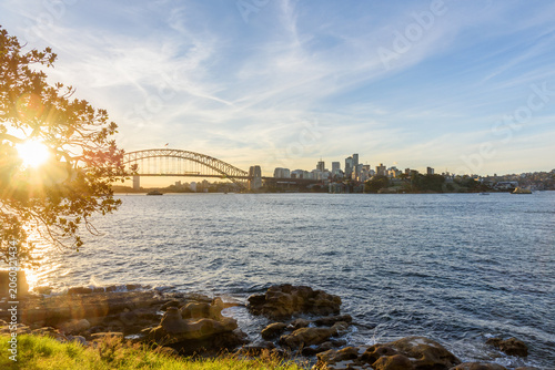 Harbour bridge and North Sydney skyline at sunset in autumn. Lens flare. NSW, Australia.