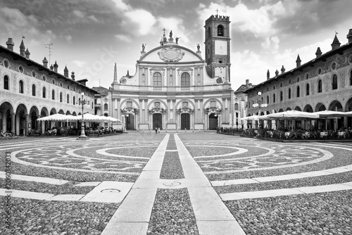 SCENIC VIEW OF PIAZZA DUCALE IN VIGEVANO, ITALY, with historic architecture, cathedral, and cobblestone pavement under a bright sky - No visible trademarks or recognizable people