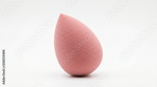 Pink makeup sponge with textured surface, isolated on a clean white background, studio lighting
