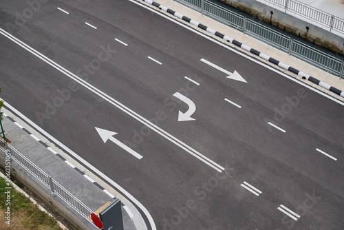 Fotografie Directional Arrows on Empty Road Symbolising Choice and Decision Making