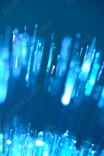 Vertical blue fiber optic lines macro shot with beautiful glowing bokeh dots.