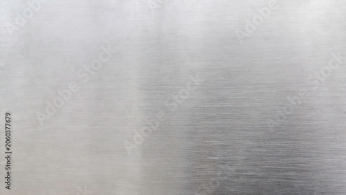 Fotografie High-resolution macro shot of a brushed stainless steel metal surface with fine linear texture and subtle light reflections for industrial design background