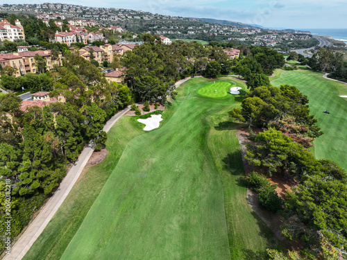 A Luxury Golf Course on the Ocean with the Greens and people playing golf as seen from an aerial UAV bear the beach and ocean