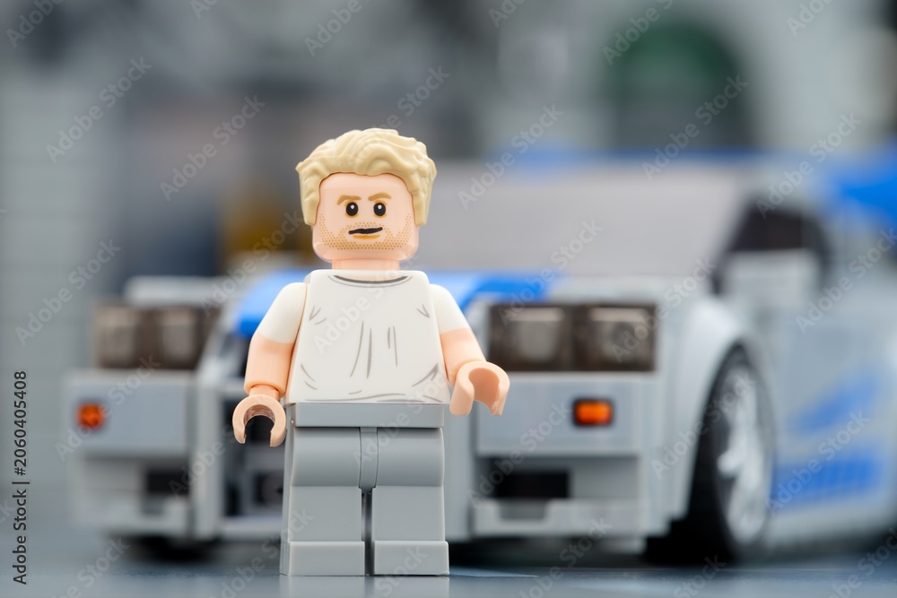 Naklejka premium Tambov, Russian Federation - August 21, 2025 Portrait of a Lego Brian OConner minifigure near his Nissan Skyline GT-R (R34) car.