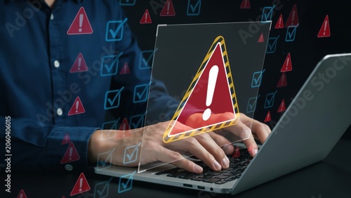 Person typing on laptop with red digital warning signs and error icons floating