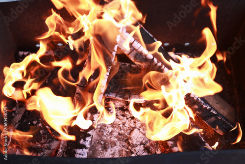 Hot firewood flames and charcoal embers for barbecue cooking