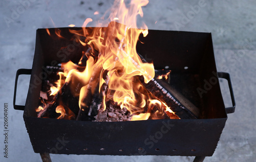 Burning firewood with orange flames and hot charcoal embers