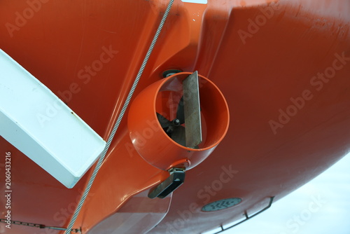 Foto Large orange lifeboat mounted on the side of a ship in Sweden, showing maritime safety equipment and nautical detail