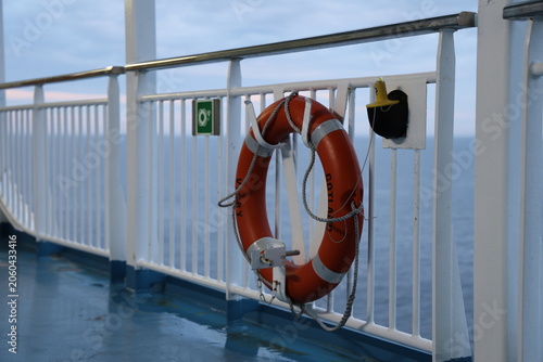 Lifebuoy and life jacket equipment on a ship, showing maritime safety gear and emergency preparedness on deck.