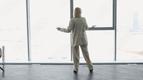 Foto Female At Large Window Observing Skyline