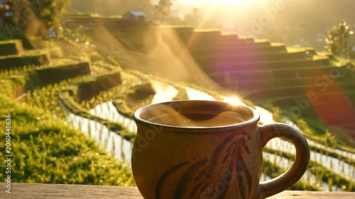 Steaming Coffee Cup Overlooking Lush Green Rice Terraces at Sunrise.