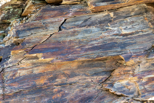 Foto Detailed frame filled with the complex, natural texture of stone layers, displaying a beautiful mix of gray, blue, and rusty orange mineral deposits