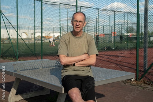 Osoba odpoczywa podczas aktywności fizycznej na boisku sportowym