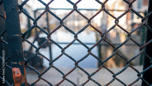 Rusty chain-link fence with blurred canal view