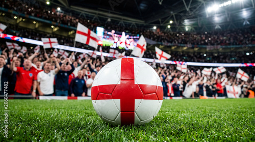 Soccer ball featuring the England flag on a soccer field with fans in the background