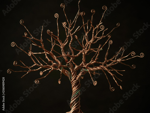 Copper wire tree sculpture with twisted metallic branches on a dark background, conceptual art of industrial nature. Generative AI.