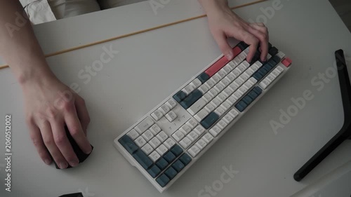 Hands playing mechanical keyboard closely. Close view of fingers on colorful keyboard. Scene of hands typing swiftly on vibrant mechanical keyboard amidst neat desk