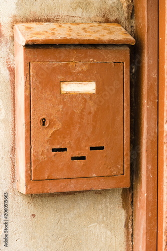 Rusty Mailbox Mounted on Exterior Wall