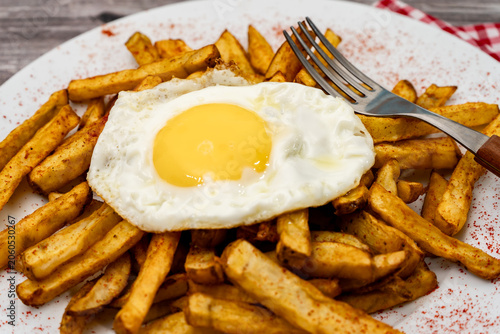 Fried egg with french fries and paprika seasoning