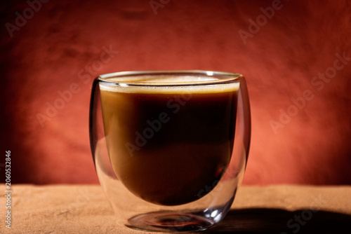Close-up of a glass cup with coffee and milk.