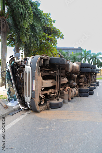 Heavy truck overturned on a city street after a traffic accident. Damaged vehicle blocking the roadway, illustrating transportation risks, road safety, and emergency situations.