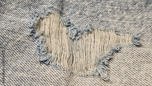 Close-up of a torn hole in jeans fabric