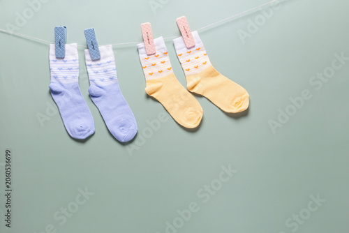 A blue children's background with small socks with clothespins on a string.