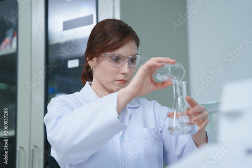 Scientist Performing Chemistry Experiment with Laboratory Glassware