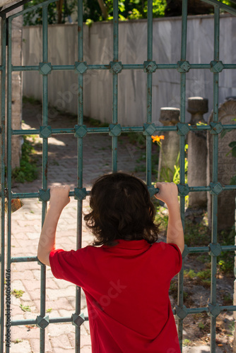 happy cute Turkish boy by the metal fence