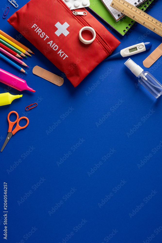 Obraz premium First aid kit and school safety supplies for student health and classroom emergencies on vertical blue table