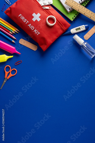 First aid kit and school safety supplies for student health and classroom emergencies on vertical blue table