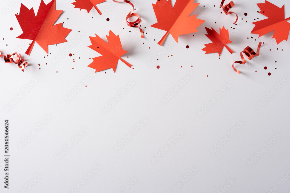 Fototapeta premium Red paper maple leaves and curled ribbons for Canada independence day celebration with confetti and blank space