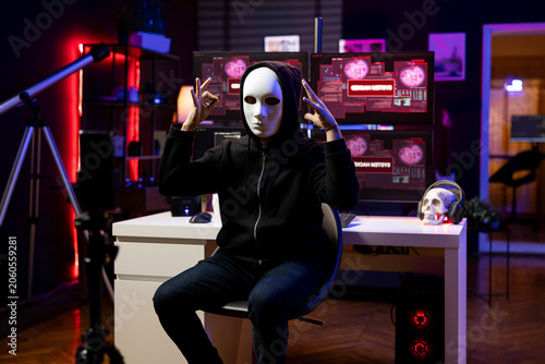 Foto Hacker claiming involvement in global government hack filming video in underground lair; rogue developer concealing identity doing international cyber warfare, blackmailing countries