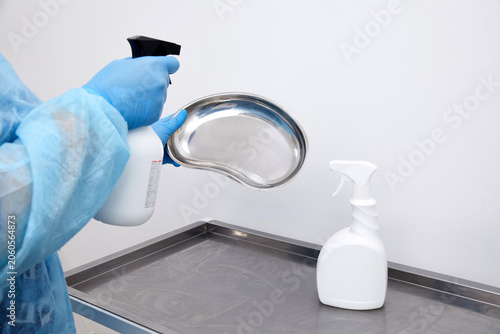 Obraz na plátne disinfecting medical instruments with sprayer in clinic