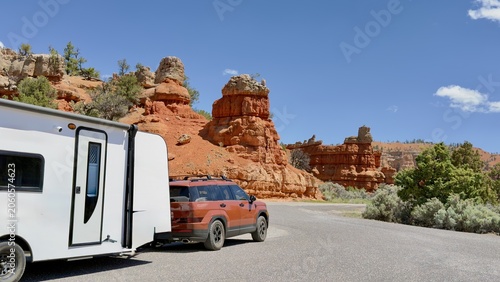 Tablou pe pânză A burgundy SUV with a travel trailer RV parked at the entrance of Dixie National Forest