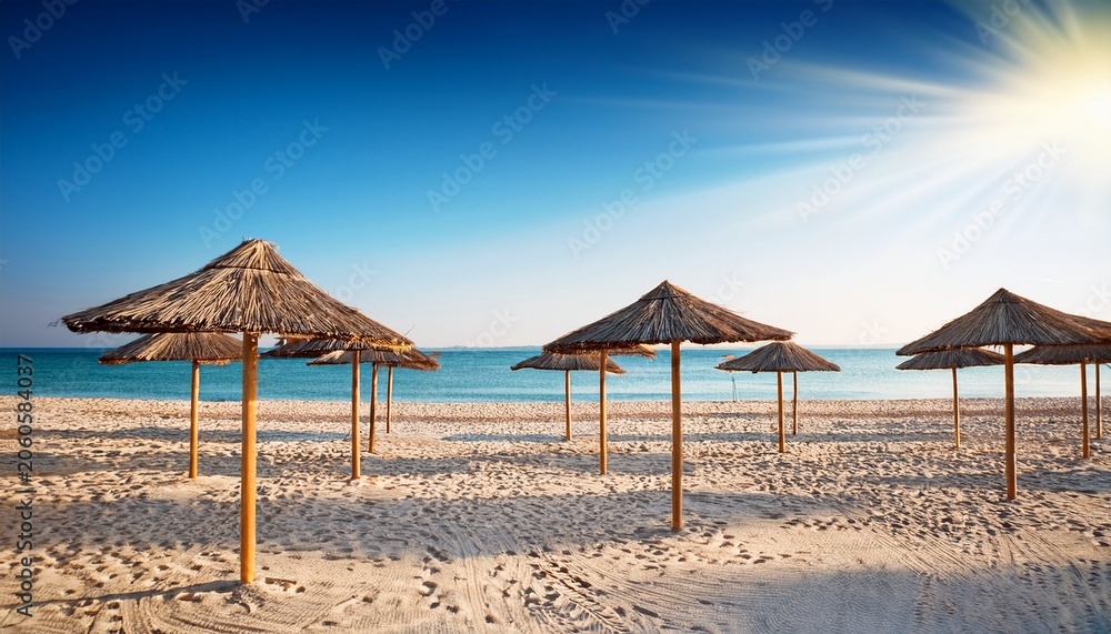 Fototapeta premium Straw Umbrellas On Empty Beach