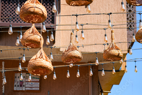 Traditional wicker ornaments and hanging light bulbs over a street in Al Balad district of Taif, Saudi Arabia