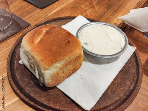 Rustic homemade bread with garlic cream on wooden board