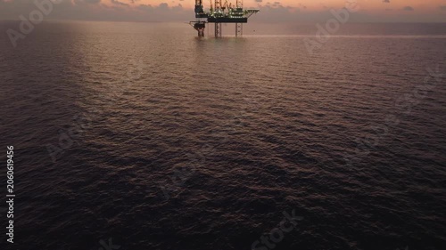 Aerial view of offshore jack up rig and offshore platform during sunset for oil and gas exploration and production. 