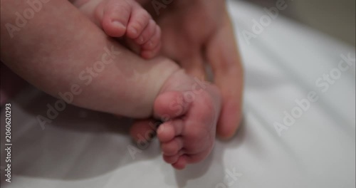 Legs and feet of a newborn baby. The baby moves its toes.