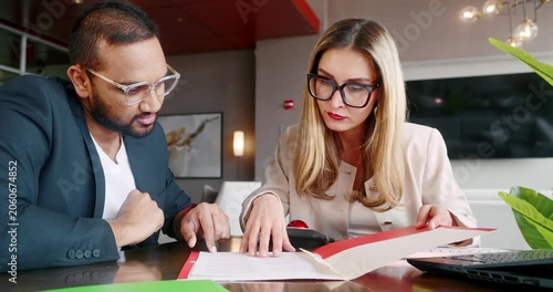 Coworkers Male and Female Analyzing Financial Reports and Documents in Office