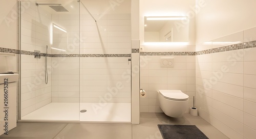 Modern minimalist bathroom with glass shower enclosure and wall mounted toilet