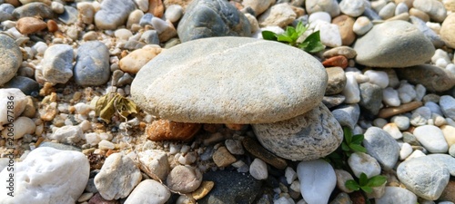 Photography Stacked hot stones on a riverbank for alternative massage therapy, representing