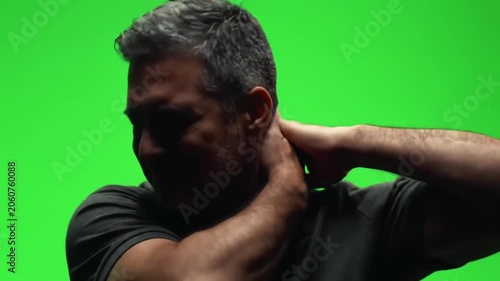 Mature man suffering from neck pain on green screen