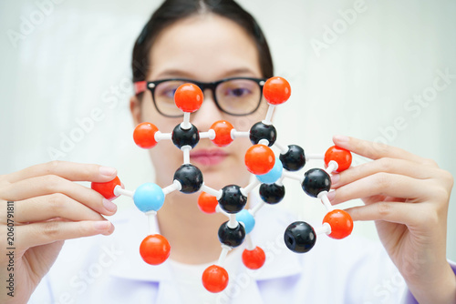 Scientist holding molecular model for chemical technology.